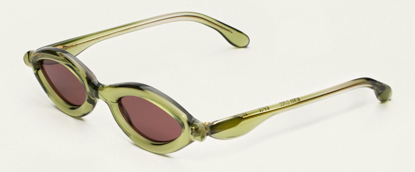 Olive-green translucent round sunglasses with red-tinted lenses on a white background.