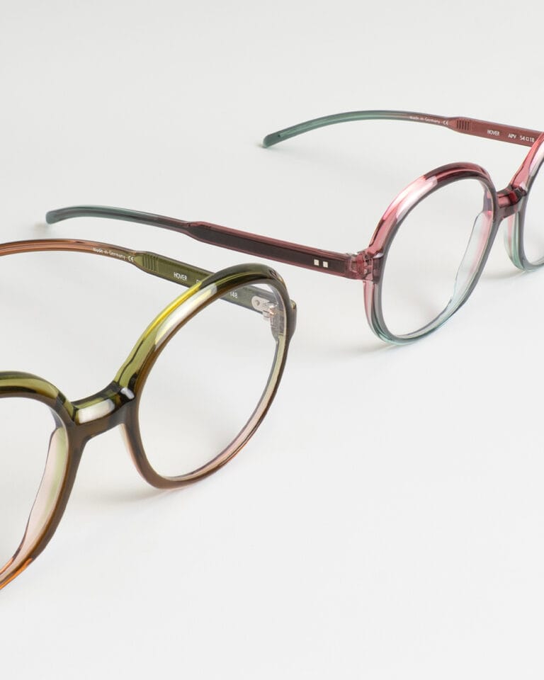 HOVER_OMV_APV | Eyestylist Three Pairs of Round-frame Eyeglasses with Translucent Brown, Pink, and Green Rims Laid on a White Surface. | Eyestylist 19th May 2026