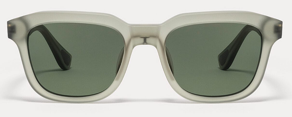Front view of white-framed sunglasses with dark green lenses on a light background.