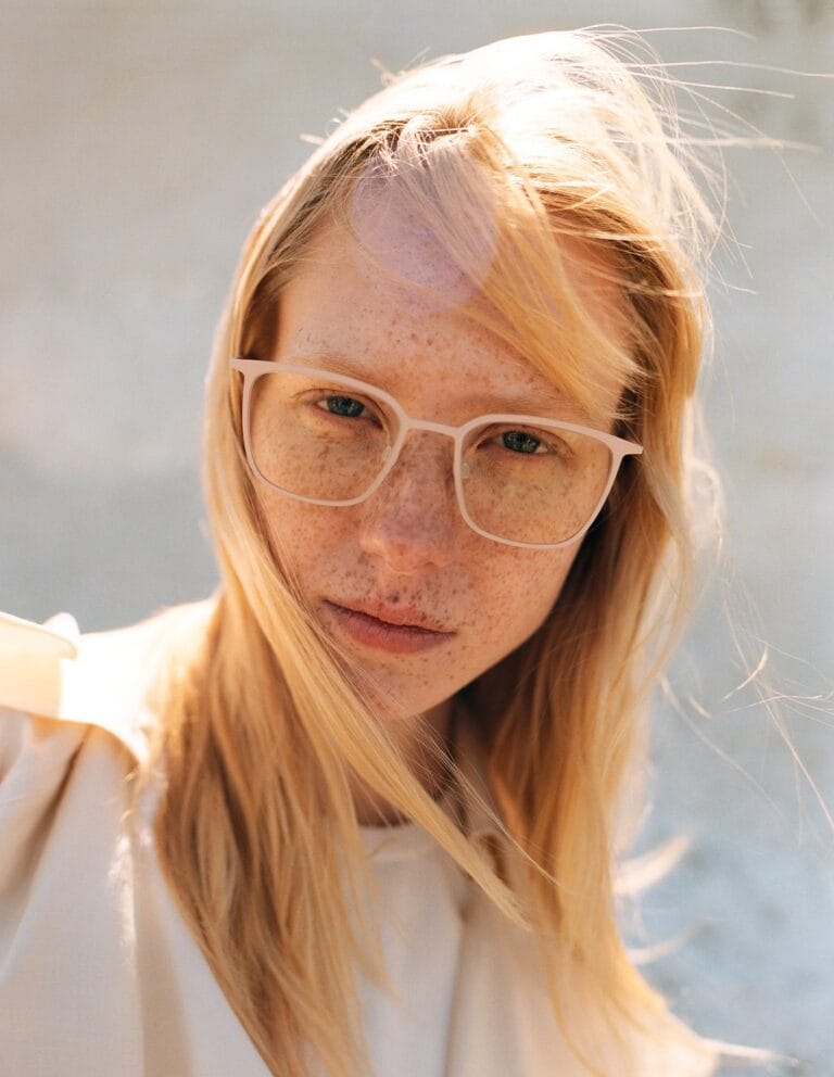 Close-up Portrait of a Light-haired Woman with White-framed Glasses and Freckles, Looking Slightly to the Camera Outdoors  | Eyestylist 30th June 2026