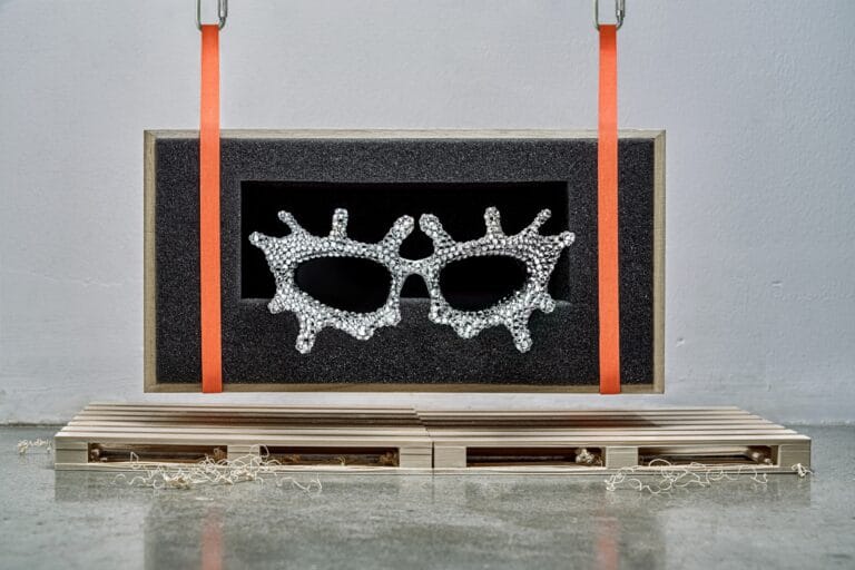 8efe70b1-57af-462b-2cec-9da9f7a7bd09 | Eyestylist Silver Rhinestone Masquerade Mask Displayed in a Black Foam Frame with Orange Straps for Hanging. | Eyestylist 29th July 2026