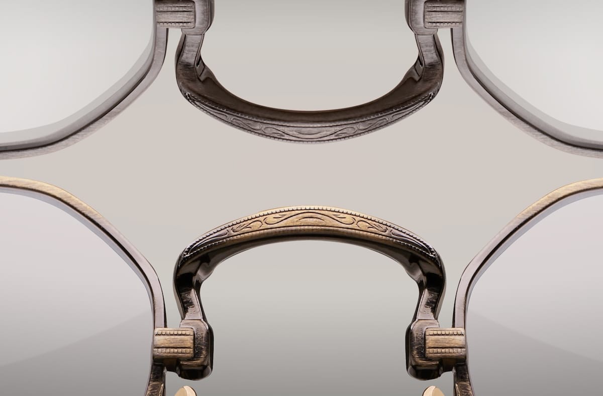 Symmetrical close-up of engraved metallic handles arranged on a reflective surface, creating a kaleidoscope-like pattern.