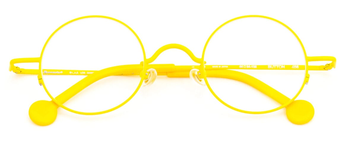 Bright yellow round eyeglasses with a matching yellow temple arms laid flat on a white surface, front view.