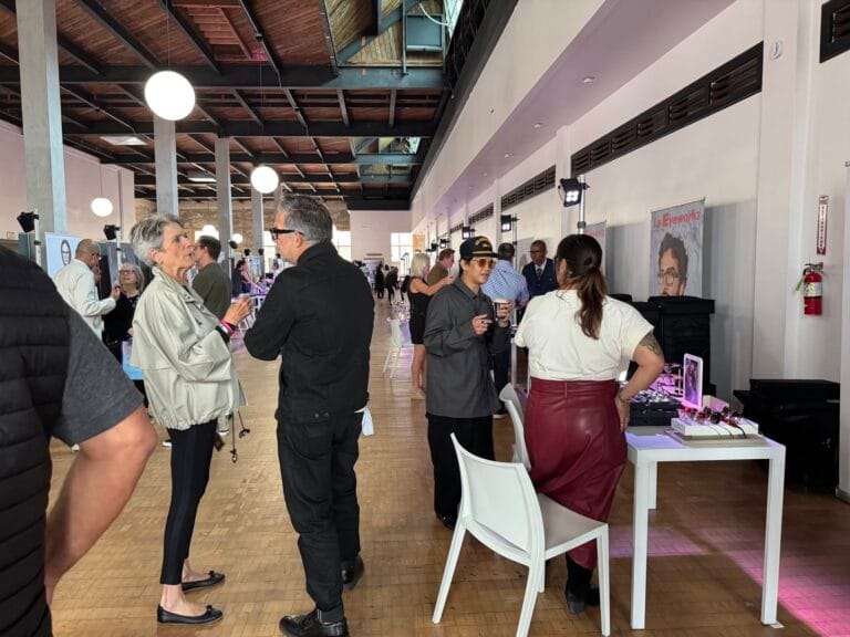 Busy Indoor Expo with Attendees Talking and Browsing Jewelry Displays Along a White Wall, White Chairs, and Round Hanging Lights Overhead.  | Eyestylist 3rd August 2026