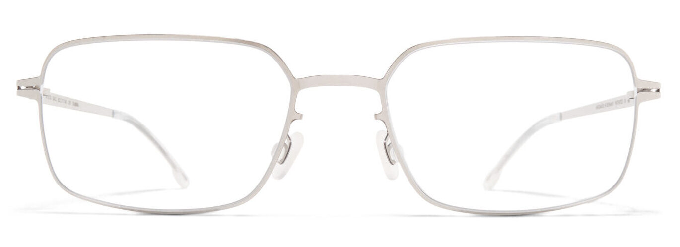 Front view of silver metal eyeglasses with white nose pads resting on a white surface near the bottom of the image