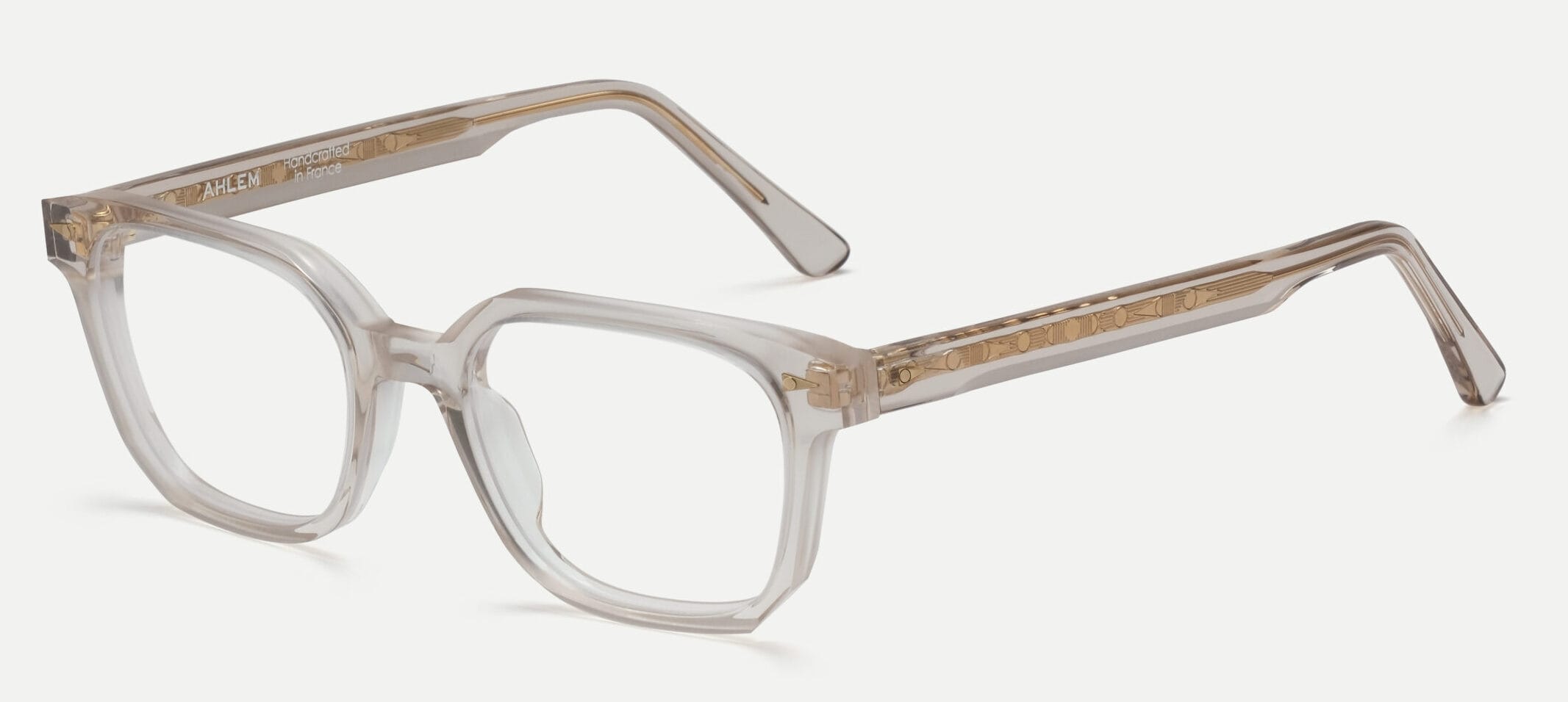 Clear-framed eyeglasses with light brown temples resting on a white background, close-up view used for product feature.