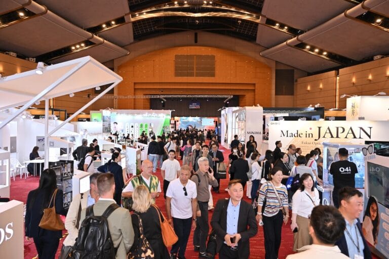 Crowded Trade Show Floor with White Booths, Banners, and Attendees Walking Among Displays in a Large Convention Hall.  | Eyestylist 4th September 2026